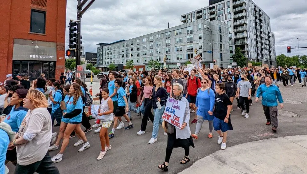 Large group of people marching in support of laws to reduce gun violence.