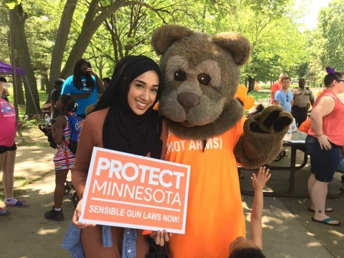 A Protect Minnesota volunteer standing next to a person in a bear costume.
