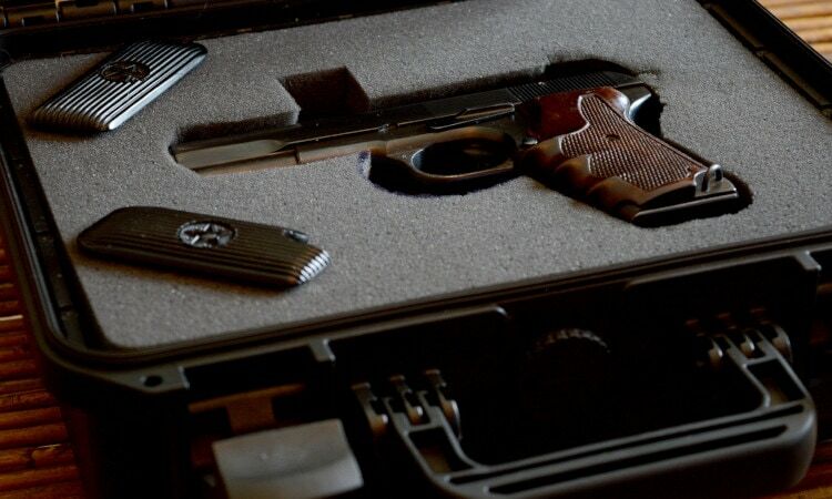 A photo of a gun in a lock box that is open showing the gun.