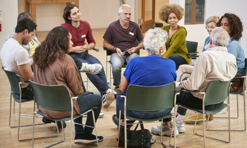 A group of people sitting in a circle talking.